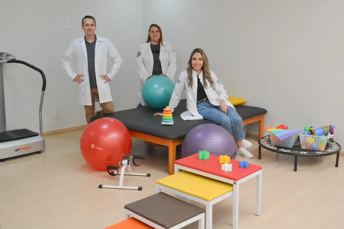 Profissionais da IntensiF na sala de fisioterapia, com bolas, degraus e outros equipamentos.